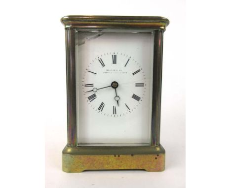 A French five glass brass cased carriage clock, the enameled face with Roman numerals and pierced hands behind beveled glass,