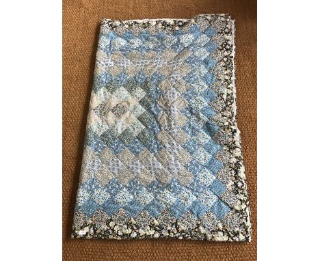 A vintage handmade patchwork quilt, worked in predominantly blue floral printed cotton blocks, 160 x 212 cm 