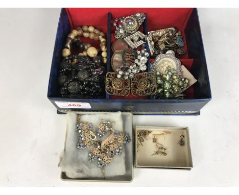 A blue faux leather jewellery box containing vintage costume jewellery, including two pairs of yellow-metal stud earrings etc