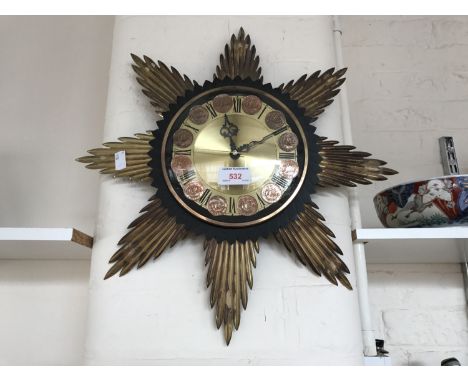 A 1970s Metamec quartz sunburst wall clock with half penny coin dial