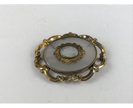 A Victorian rolled gold brooch, set with a faux-opal cabochon, over imitation rock crystal