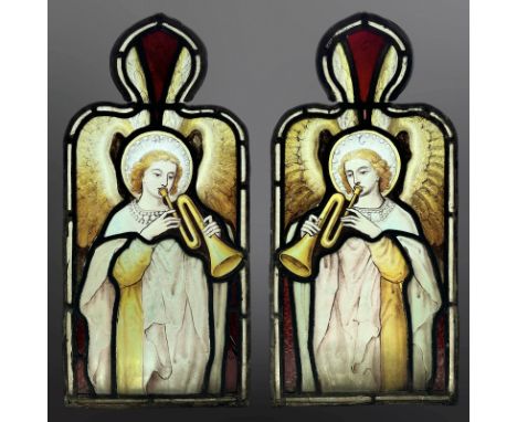 A pair of Angel Trumpeteers, two trapezoidal stained, painted and leaded glass windows with ogee pediments, each 50.5cm by 24