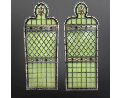 A pair of lancet windows, clear and pale green stained-glass, with central clear and amber glass roundels, within two borders