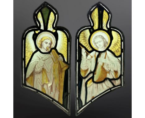 A pair of Angel Musicians, a trumpeteer and a drummer, two trapezoidal green-stained, painted and leaded glass windows with o
