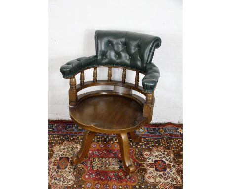 An Edwardian mahogany swivel desk chair, with green leather button back and circular seat