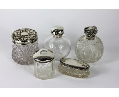 Five early 20th century silver topped dressing table jars, to include; A jar with floral embossed cover 'BP DC' Birmingham 19