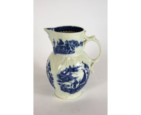 An 18th century Caughley porcelain cabbage leaf moulded mask jug, blue printed in the fisherman pattern, 19cm high (restored)