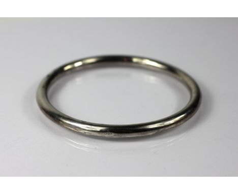 A silver slave bangle, Chester 1920, of plain polished form, 8.7cm diameter, weight 16.4gms