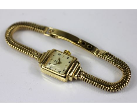 A lady's Omega 9ct yellow gold wristwatch, manual wind, the stepped case with square face, champagne coloured dial and Arabic