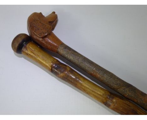 A Hand Carved Hazel Walking Stick, depicting a Spaniel, together with one other. (2)