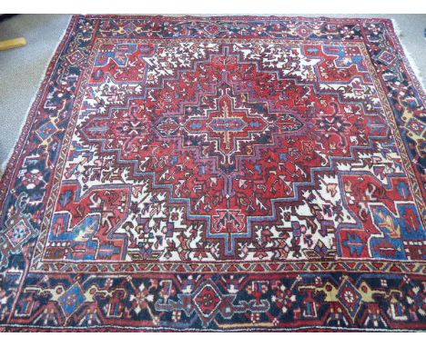 A Vintage Circa 1920's "Heriz" Carpet,, with jewel colours and of geometric design, with label to verso Iranian made, approx 