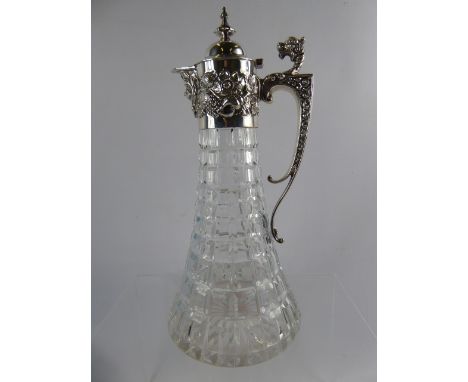 A Silver Topped Cut Glass Flat Bottom Claret Jug, the claret jug decorated with shells and grapes to collar with dragon form 