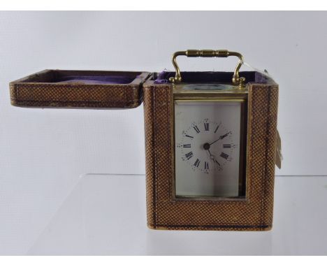 A French Brass Carriage Clock, movement stamped SFRA, white enamel face, Roman dial, in the original leather box with key. (a