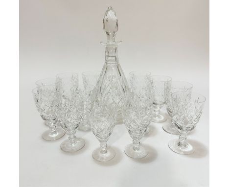 A crystal slice cut and thumb cut tapered decanter with faceted stopper, (h 34cm), slight chip to rim, and a set of eight cry