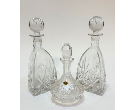 A pair of crystal slice cut triangular shaped decanters complete with ball stoppers, show no signs of damage, chips or repair