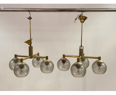 A pair of lacquered brass four branch ceiling light fittings, circa 1970's, each branch with a domed shade, H59cm