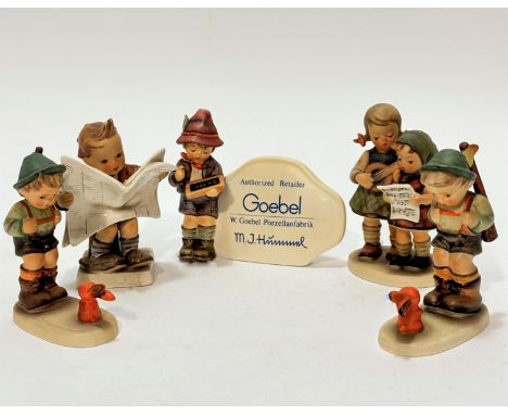 A Hummel pottery group Close Harmony (13.5cm x 8cm), a Goebel Hummel figure, authorised retailer sign, a seated figure Close 