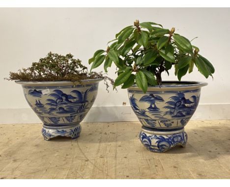 A large matched pairs of Chinese blue and white ceramic vases of squat flared form, naively painted with typical landscapes, 