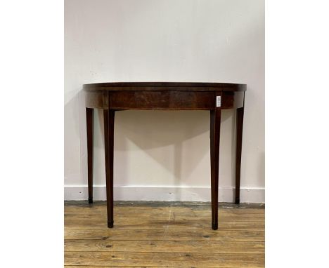A Georgian mahogany demi lune card table, the rosewood cross banded, boxwood and ebonised strung top folding to reveal a baiz