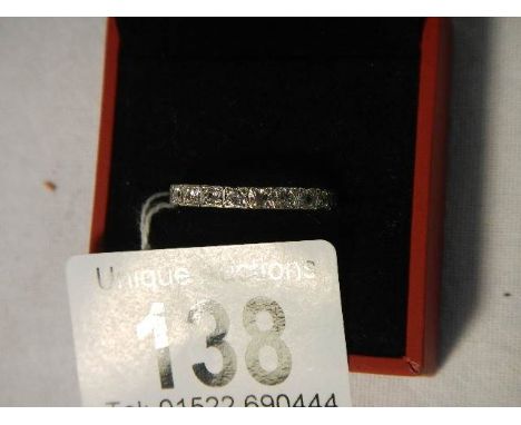 A 9ct white gold band ring set with white stones, stamped J H.  Weight 3.6 grams, size R.