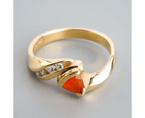 A fire opal and diamond dress ring. Set with a triangular shape facted fire opal, to the round brilliant cut diamond sides, a