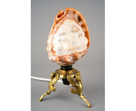 An Italian conch shell carved with a Classical Maiden motif on brass tripod base, converted to lamp, approx 21cm high overall