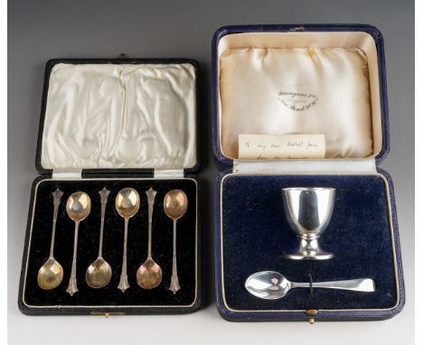 A George VI plain silver egg cup and spoon, hallmarked by Wakely &amp; Wheeler, London, 1946, in fitted case and a cased set 