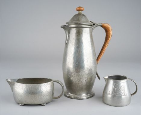A Liberty &amp; Co English pewter hot water / coffee pot, planished with ratan handle, number 0138 together with a Tudric pla