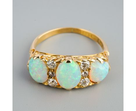A late Victorian 18ct gold opal and diamond ring. Set with oval opal cabochons interspaced by old cut diamonds, one opal chip