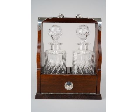 A Modern stained wood white metal mounted Tantalus complete with a pair of cut glass spirit decanters, with key