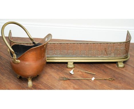 A Victorian style copper coal scuttle of helmet form, on three cabriole legs, together with a brass fender with pierce front,