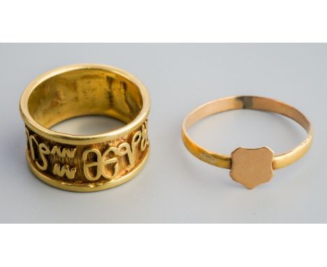 Two rings. To include a  id 20th century band ring with Egyptian symbols (ring unmarked), together with a plain band ring wit