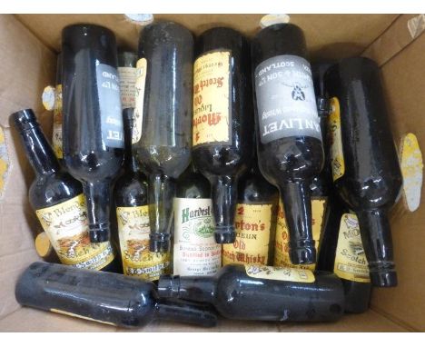 A collection of glass Scotch whisky bottles with original vintage labels.