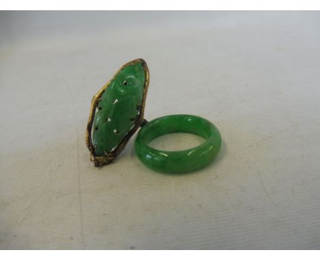 An unusual gold ring mounted with a carved piece of jade in the shape of a leaf, size G and a jade ring, size H.&nbsp;