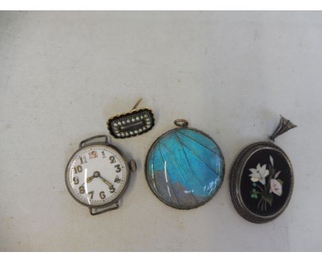 A late Victorian Pietra Dura oval glass backed locket within a silver frame, a silver wristwatch, a mourning brooch enraved R