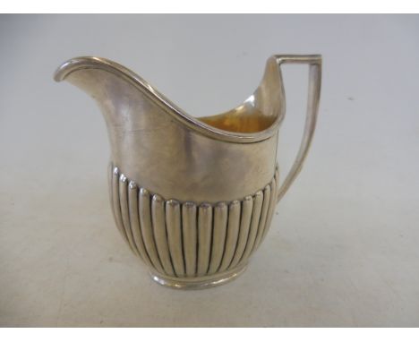 A silver half fluted cream jug, London 1903, approx. 140.4g.