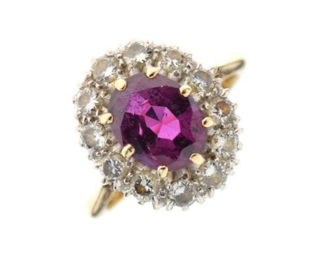 Ruby and diamond cluster ring, the oval cut calculated as weighing approximately 2.1 carats, enclosed by twelve brilliant cut