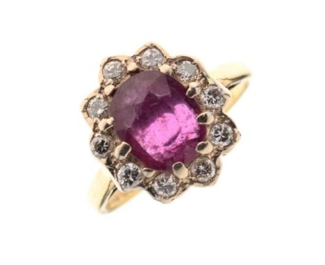 18ct gold ruby and diamond cluster ring, the oval cut ruby enclosed by ten brilliant cuts totalling approximately 0.25 carats