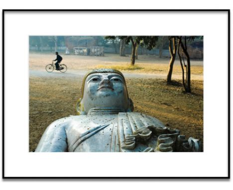 STEVE McCURRY 'A Man Rides past a Buddha Statue in a Park in Mandalay, Burma', lithograph, edition of 50, signed, 50cm x 30cm