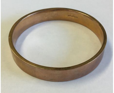 A 9 carat plain slave bangle. Approx. 16 grams. Est. £120 - £150.
