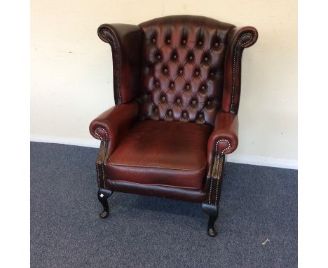 A leather button back smoker's chair on cabriole legs. Est. £60 - £80.