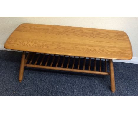 An Ercol occasional table on tapering supports. Est. £40 - £60.