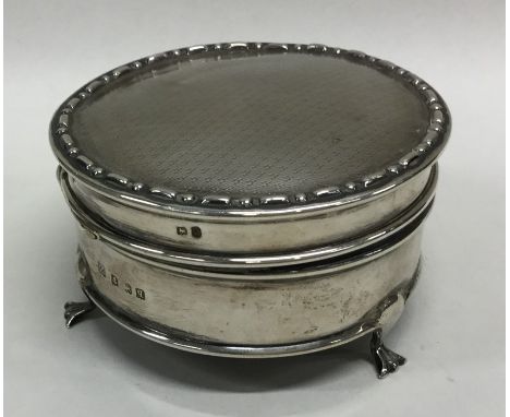 A circular silver hinged top jewellery box with engine turned decoration. Birmingham. Approx. 120 grams. Est. £50 - £80.