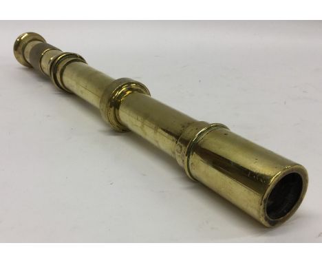 An unusual brass telescope with engine turned handle. Approx. 43 cms long. Est. £30 - £40.