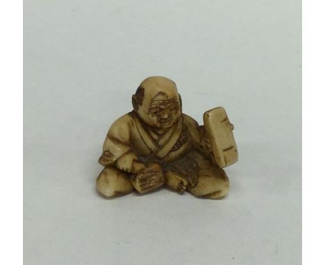 A small modern netsuke in the form of a Buddha in seated position. Est. £30 - £40.