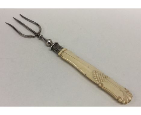 An unusual Edwardian silver three prong bread fork with carved handle. Approx. 62 grams. Est. £15 - £20.