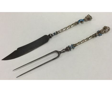 An early silver and enamelled matching steak knife and fork, the terminals mounted with busts of figures. Approx. 76 grams. E
