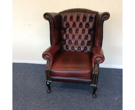 A leather button back smoker's chair on cabriole legs. Est. £60 - £80.