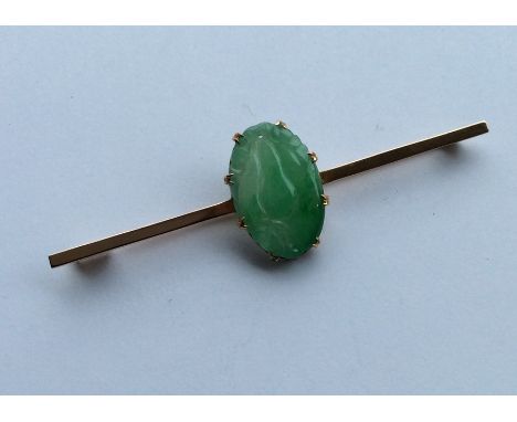 A large oval jade carving mounted on a high carat gold brooch. Approx. 11 grams. Est. £200 - £250.