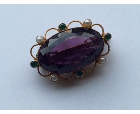 SUFFRAGETTE: A rare amethyst oval brooch with pearl and emerald border in 15 carat gold. Approx. 13 grams. Est. £400 - £600.